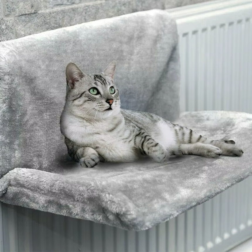 Grijze radiator hangmat over de verwarming met kat